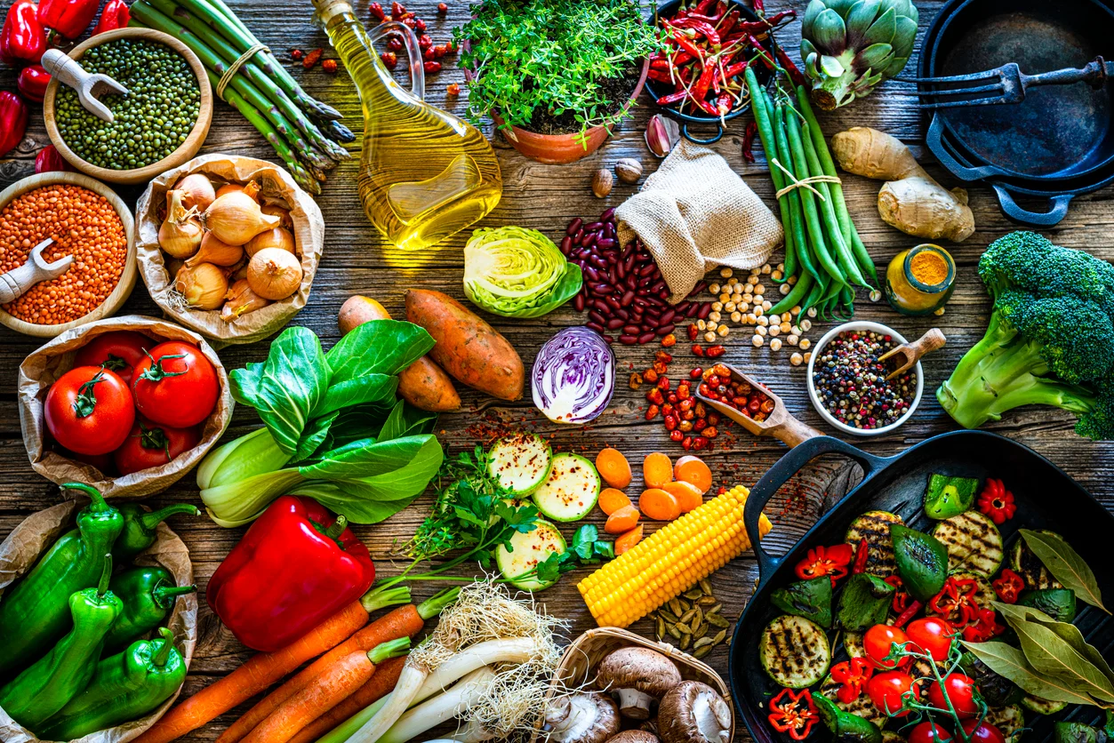 A huge selection of fruits and vegetables on a wooden table